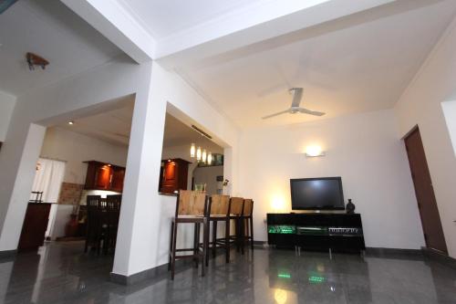 a living room with a tv and a table and chairs at Angel villa in Negombo
