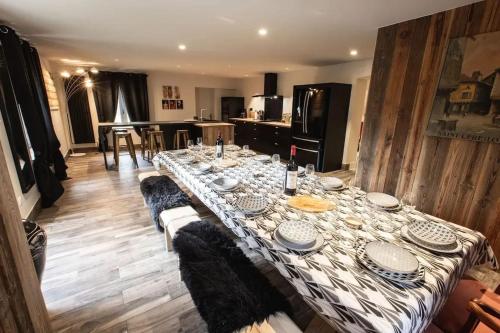 - une grande table avec des assiettes dans la cuisine dans l'établissement Grande maison à Vielle-Aure avec cheminée, à Vielle-Aure