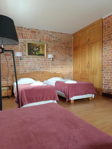 a bedroom with two beds and a brick wall at Na Plebanii in Jaszkowo