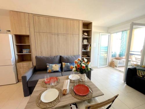 un salon avec une table et un canapé dans l'établissement Studio avec vue mer à Six-Fours - parking, à Six-Fours-les-Plages