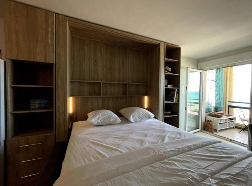 une chambre avec un grand lit et une grande fenêtre dans l'établissement Studio avec vue mer à Six-Fours - parking, à Six-Fours-les-Plages