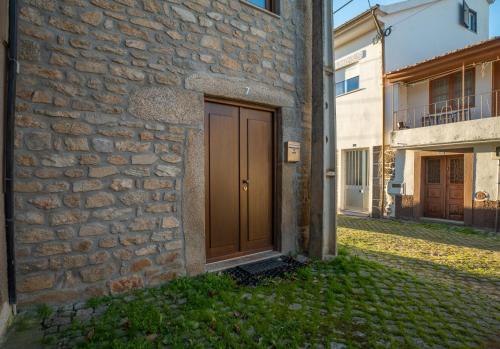 a brown door on the side of a stone building at Casa d'Amêndoa in Felgar
