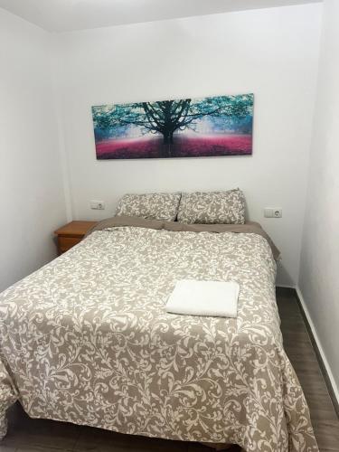 a bedroom with a bed and a tree on the wall at Villas de encanto in Vilamarxant