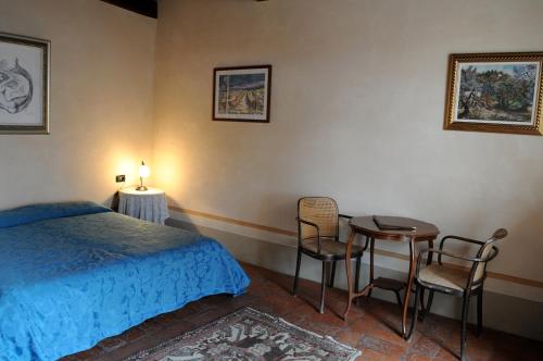 a bedroom with a bed and a table and chairs at I Casali del Trebbiolo in Molino del Piano