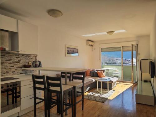 a kitchen and living room with a couch and a table at Apartman Srna in Trebinje