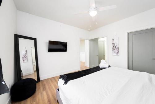 a bedroom with a white bed and a mirror at Refined Living in a Vibrant Locale Dream Stay in Pflugerville