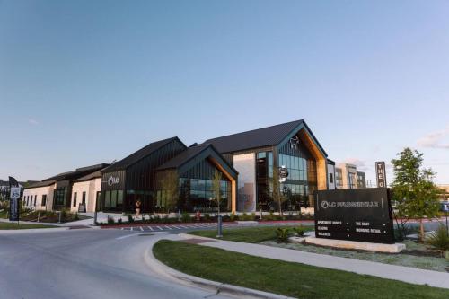 a building with a sign in front of a street at Luxurious 1BR Gem Steps from the Action in Pflugerville