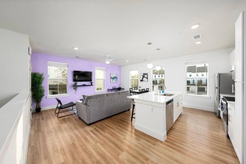 a living room with purple walls and a gray couch at Luxurious 1BR Gem Steps from the Action in Pflugerville