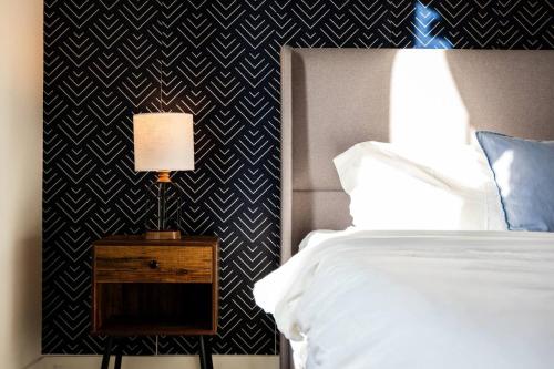 a bedroom with a bed and a table with a lamp at Luxurious 1BR Gem Steps from the Action in Pflugerville