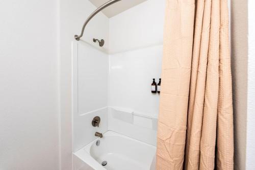 a bathroom with a shower curtain next to a tub at Luxurious 1BR Gem Steps from the Action in Pflugerville