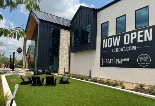 a new open sign on the side of a building at Luxurious 1BR Gem Steps from the Action in Pflugerville