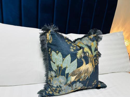 a pillow with a bird on it sitting on a bed at Hotel No5, Beachfront with Free Private Car Park in Llandudno