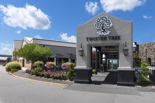 a twisted tree sign in front of a building at Holiday Inn St Louis SW - Route 66 by IHG in Saint Louis