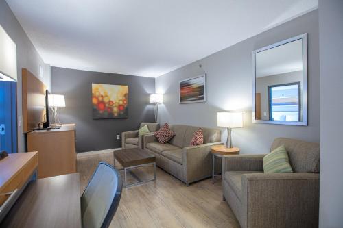 a living room with two couches and a table at Holiday Inn St Louis SW - Route 66 by IHG in Saint Louis