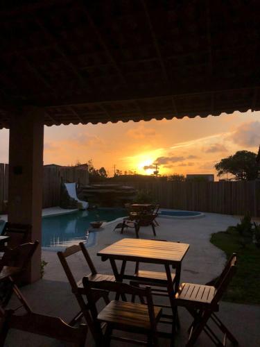 a table and chairs on a patio with a sunset at Pousada Santo Amaro in Santo Amaro