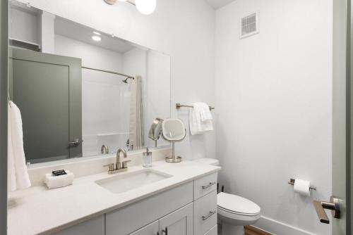 a white bathroom with a sink and a toilet at Luxury Stay 1B 1B w Gym, Pool, Shops Nearby in Pflugerville