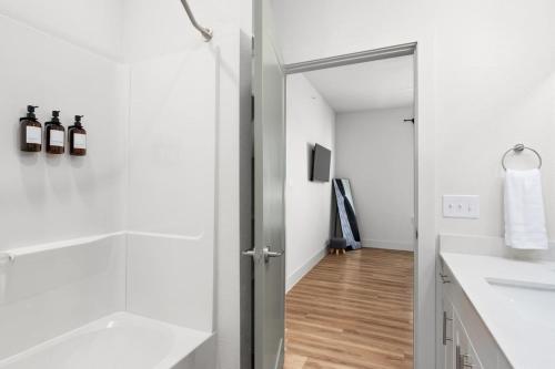 a white bathroom with a shower and a sink at Luxury Stay 1B 1B w Gym, Pool, Shops Nearby in Pflugerville