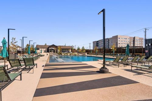 a pool with chaise lounge chairs and a swimming pool at Luxury Stay 1B 1B w Gym, Pool, Shops Nearby in Pflugerville