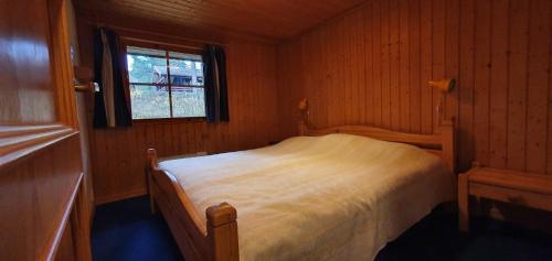 a small bedroom with a bed and a window at Sauna | Wi-Fi | Terrace | Wood stove | Cable TV in Lofsdalen