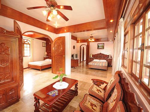 a living room with a ceiling fan and a bedroom at Blue Crystal Beach Resort in Puerto Galera