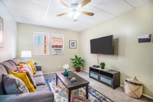 a living room with a couch and a flat screen tv at Historic Avenues Apartment Downtown in Salt Lake City