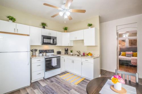 a kitchen with white cabinets and a ceiling fan at Historic Avenues Apartment Downtown in Salt Lake City