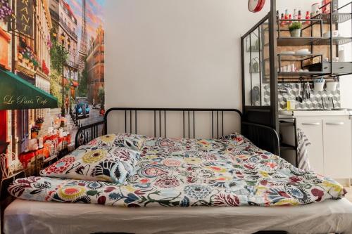 パリにあるStudio Paris - Métro 7 Cadet - Quartier Faubourg-Montmartreの花の咲く毛布付きのベッド1台