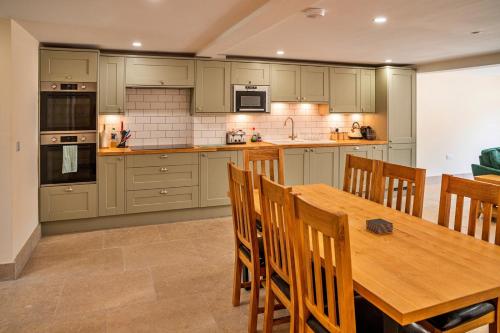 a kitchen with a wooden table and chairs at Little Rissington - Barn Six in Little Rissington