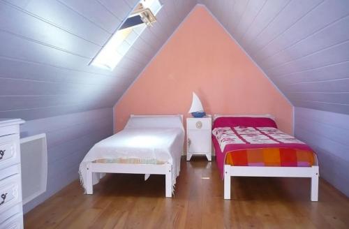 - 2 lits dans une chambre mansardée dans l'établissement Maison de la plage avec Piscine - Breizh Location, au Guilvinec