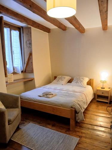 a bedroom with a bed and a chair and a lamp at Au Coeur Des Alpes in Villarodin-Bourget