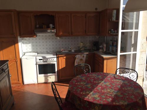 La cuisine est équipée d'une table et de plaques de cuisson blanches. dans l'établissement Brémailles41, à Onzain