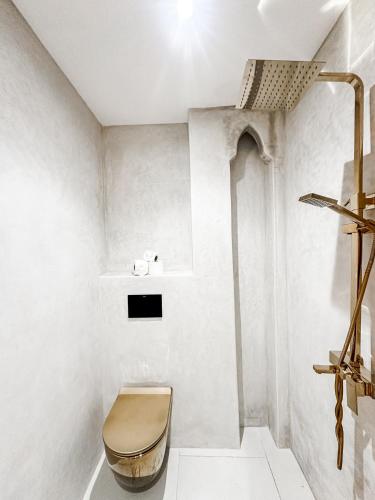 a white bathroom with a toilet and a shelf at La Finca - 3BR Seaside Villa with Private Pool & BBQ in Tangier