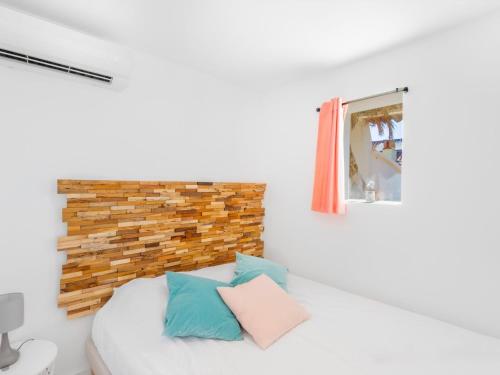 une chambre blanche avec un lit avec des oreillers bleus et roses dans l'établissement Apartment Gimelli by Interhome, à Toulon