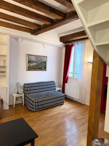 - un salon avec un canapé et un rideau rouge dans l'établissement Le 64 Rue Chapon, à Paris