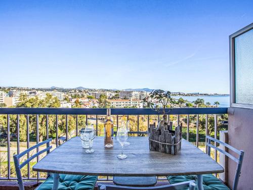 - une table en bois avec des verres à vin sur le balcon dans l'établissement Apartment Le Cagnes Beach-4 by Interhome, à Cagnes-sur-Mer