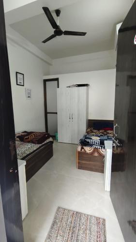 a room with two beds and a ceiling fan at Capsule Hostel And PG Services in Gorakhpur