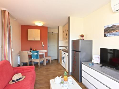 un salon avec un canapé rouge et une cuisine dans l'établissement Apartment Village Cap Estérel - L'Esquinade-110 by Interhome, à Agay