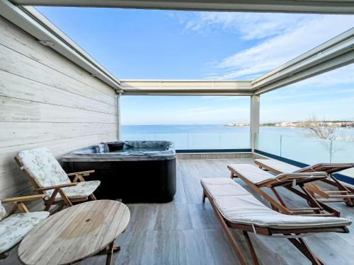 a screened in porch with chairs and a large window at Apartment Villa Škoda by Interhome in Povljana