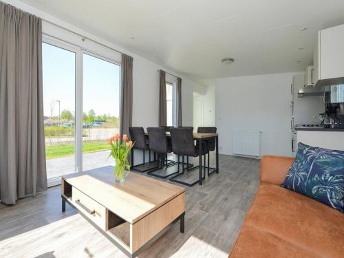 un soggiorno con un divano e un tavolo di Holiday Home Hart van Zeeland by Interhome a heinkenszand