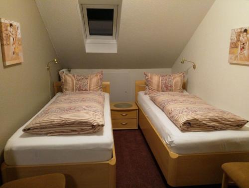 two twin beds in a small room with a window at Ferienhaus am Sonnenhang in Willingen
