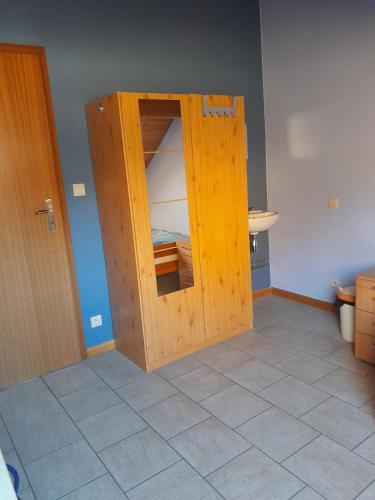 a wooden door in a room with a bedroom at Grande chambre au coeur de la gaume - Chambre 1 - 2ème étage in Virton