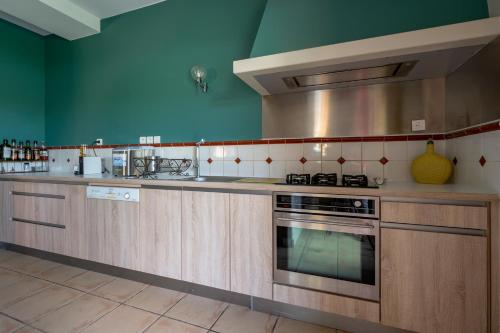 a kitchen with wooden cabinets and a stove top oven at La Petite Toscane en Beaujolais in Saint-Vérand