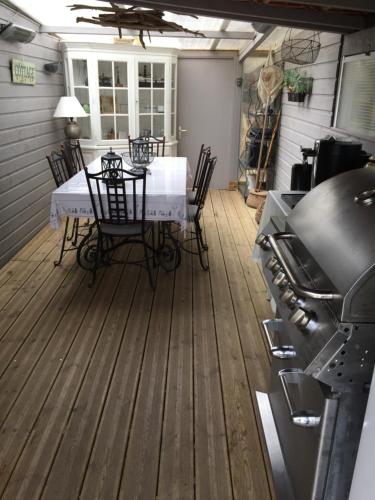 une terrasse avec une table, des chaises et une cuisinière dans l'établissement maison avec piscine, à Saintes