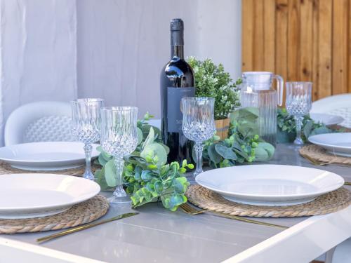 a table with plates and glasses and a bottle of wine at Holiday Home Doria by Interhome in La Ciaccia