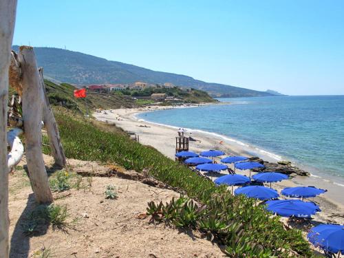 a group of blue umbrellas on a beach at Holiday Home Doria by Interhome in La Ciaccia