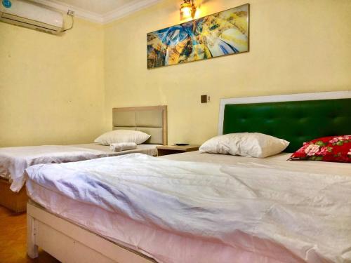 a bedroom with two beds and a painting on the wall at Sea inn guest house in Sihanoukville
