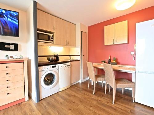 une cuisine avec un lave-linge, une table et des chaises dans l'établissement Apartment Village Cap Estérel - Le Village-81 by Interhome, à Agay