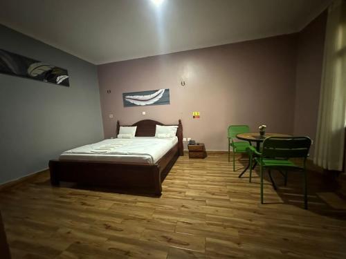 ein Schlafzimmer mit einem Bett und einem Tisch und Stühlen in der Unterkunft REBERO RESORT Ltd in Kigali