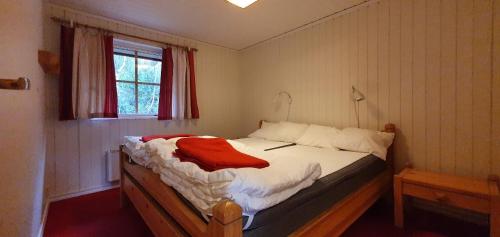 ein Schlafzimmer mit einem Bett mit einem roten Hemd drauf in der Unterkunft Sauna | Wi-Fi | Terrace | Wood stove | Cable TV in Lofsdalen