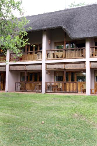a building with balconies and a lawn in front of it at Cresta Mowana Safari Resort & Spa in Kasane